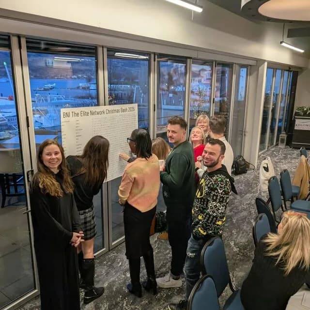 A group of coworkers solving a giant custom word search at a Christmas party